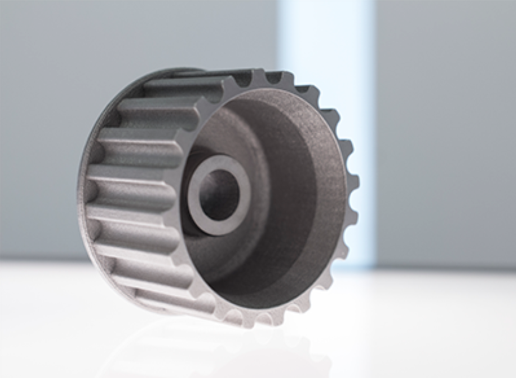 A metallic 3D-printed gear-like part with precise grooves and a sleek finish.