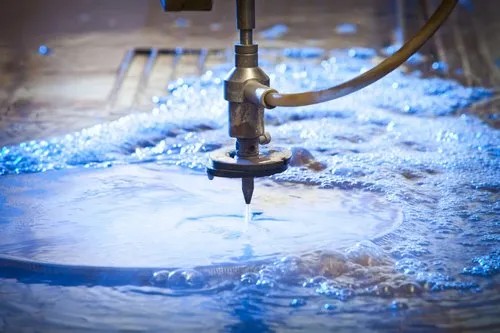 Close-up of a water jet cutter in action, showcasing precision cutting in a pool of water.