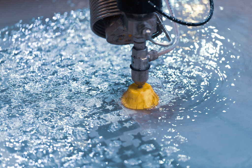 Close-up of a water jet cutter in action, showcasing precision cutting in a pool of water.