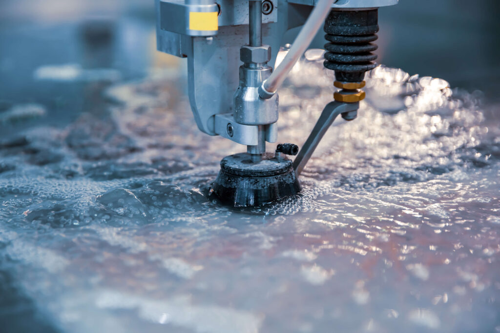 Close-up of a water jet cutting machine working on a marble surface, showcasing precision and advanced technology.