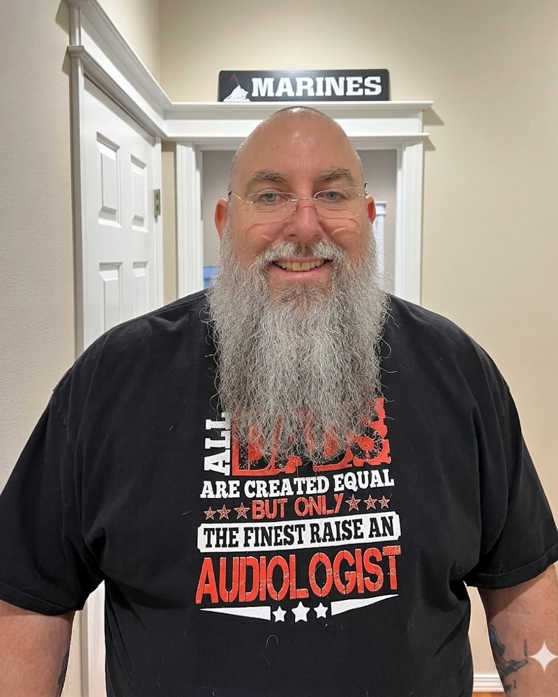 Craig Rose, owner of Treasure Valley 3D, standing in front of a Marines sign